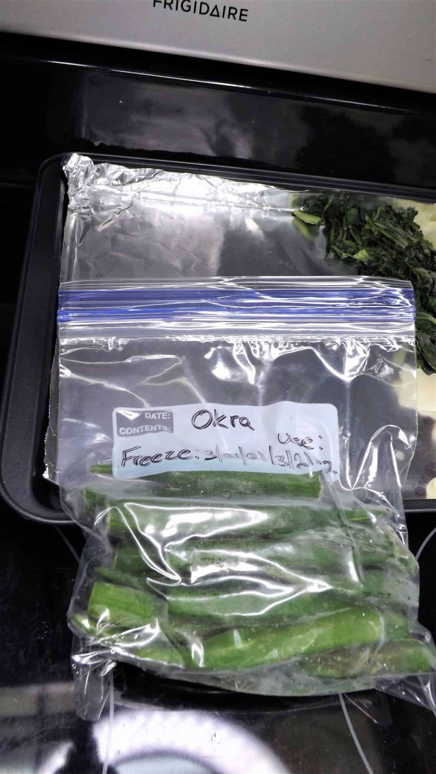 freezer bags of frozen okra in front of baking pan wrapped in foil