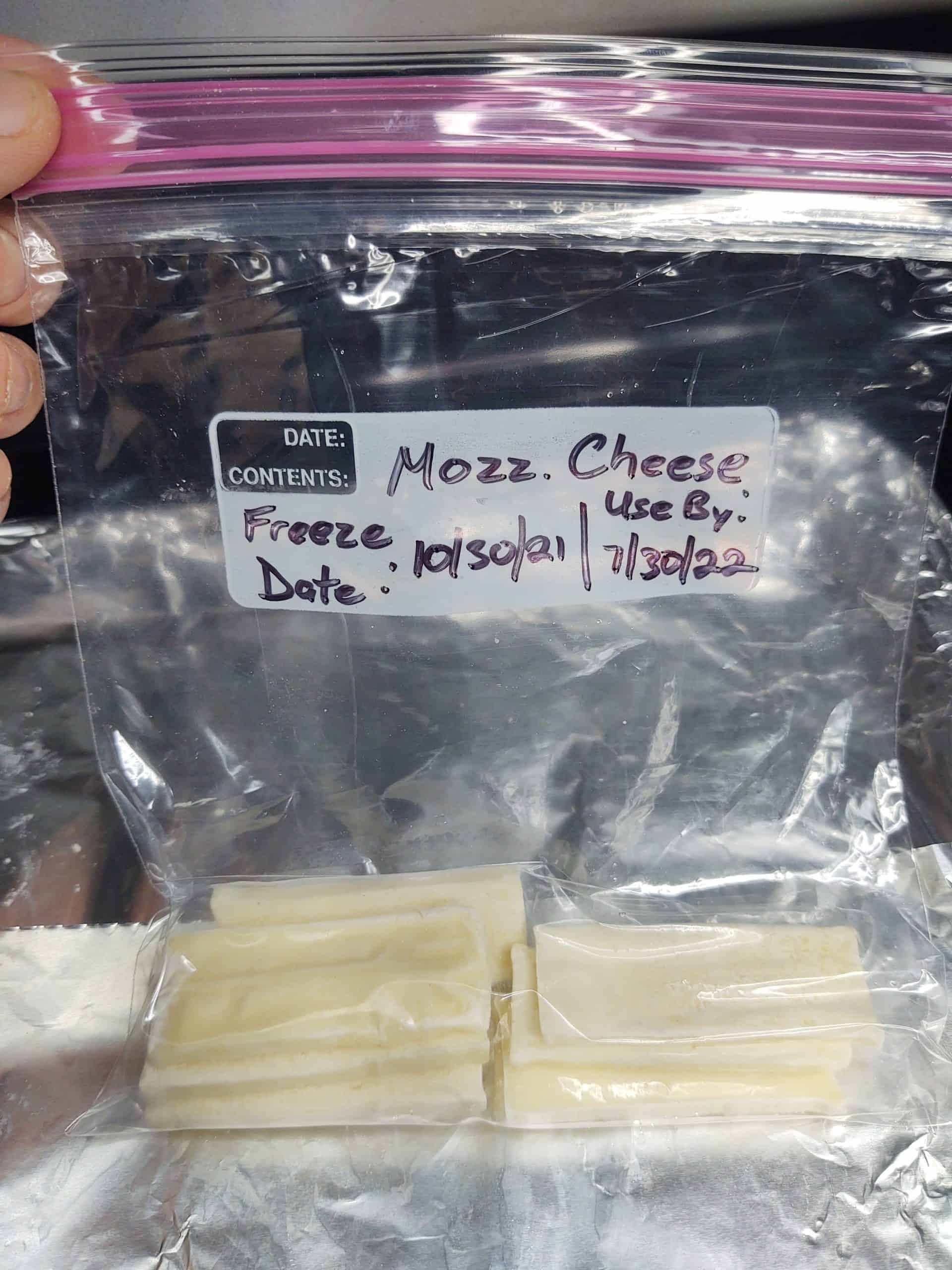 freezer bags of frozen mozzarella in front of baking pan wrapped in foil