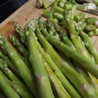 fresh cut asparagus on cutting board