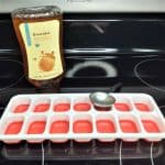 honey, measuring spoon, and ice cube tray on stovetop