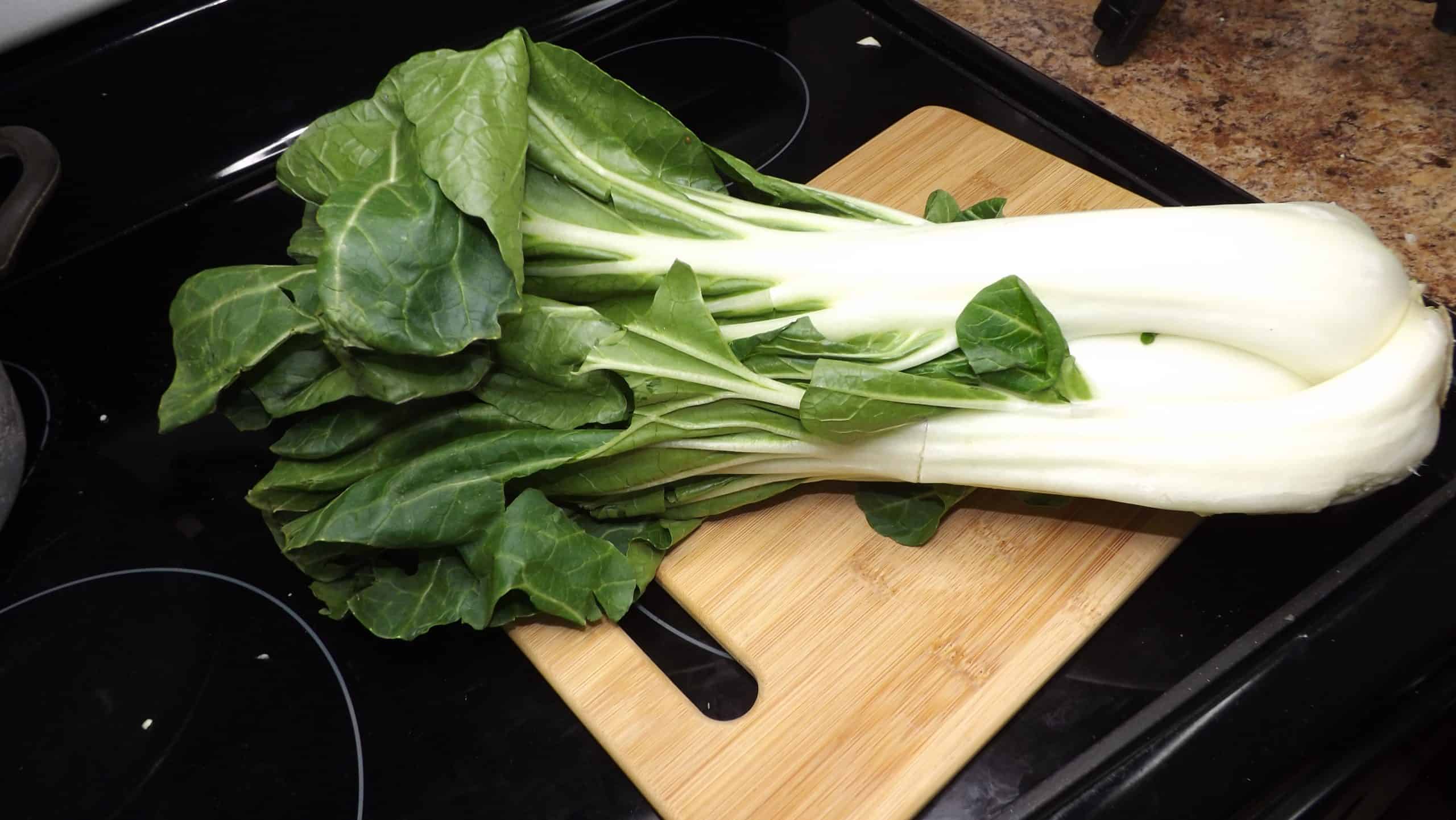 bok choy on cutting board sitting on stove