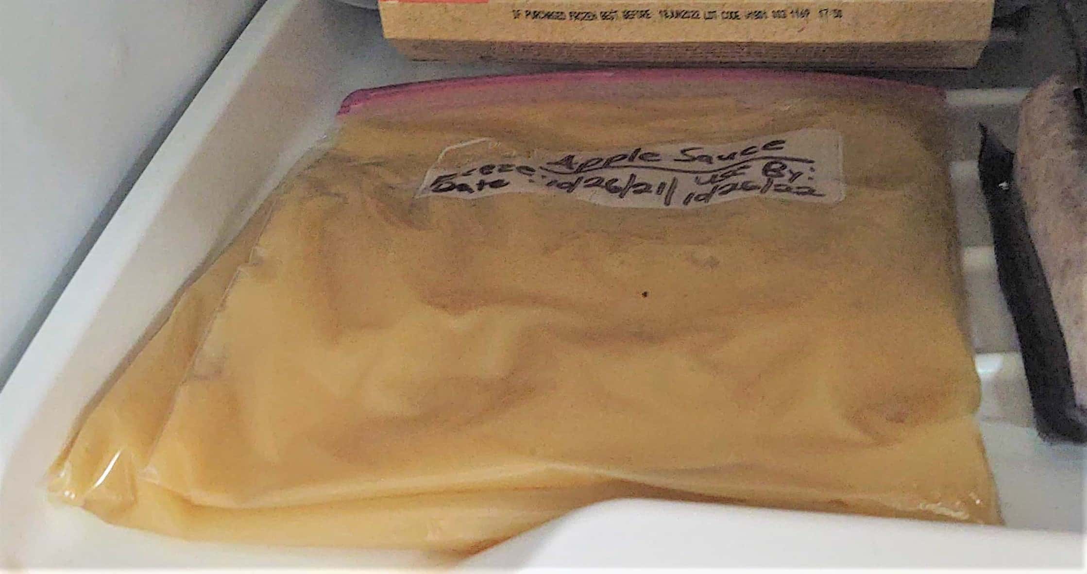 bag of apple sauce laid flat in freezer