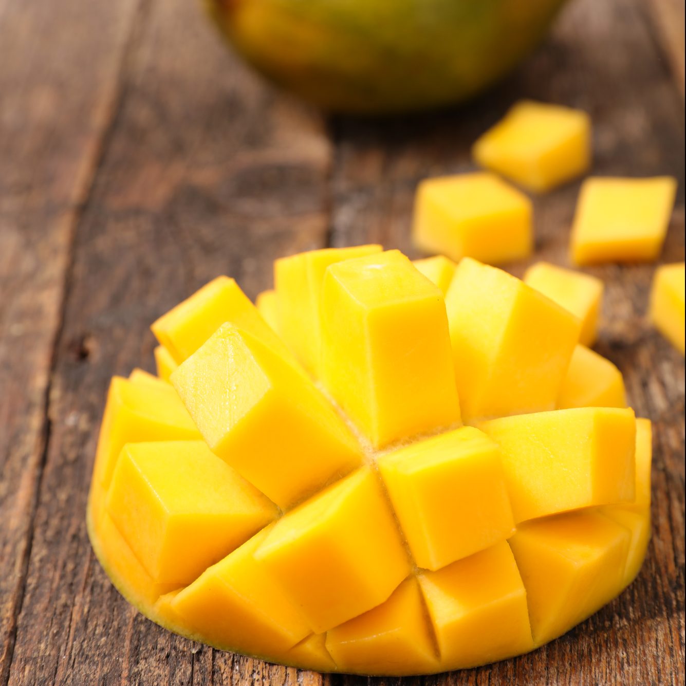 mango cut into cubes on wooden table